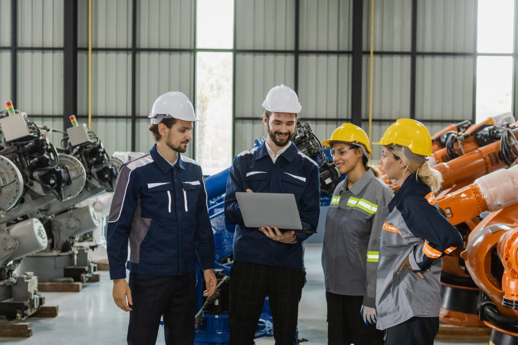 Engineers working robot assembly industry plant in factory, talking, meeting, examining condition inspection quality robotic arm. teamwork technician robotic industrial.